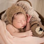 baby wearing brown knit cap while sleeping