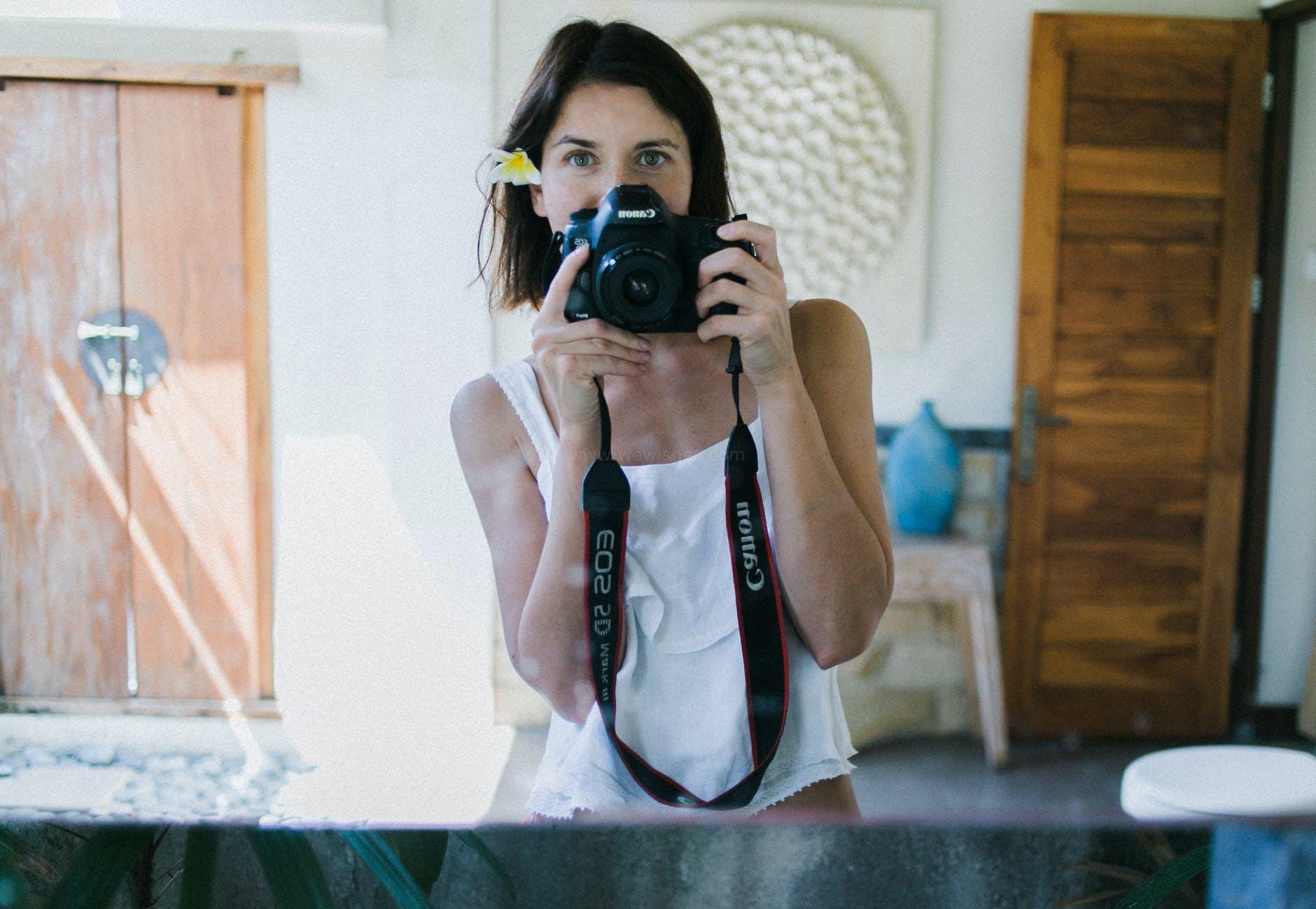beautiful woman taking selfie in bright room