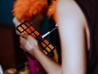 woman with eyeshadow kit in dressing room