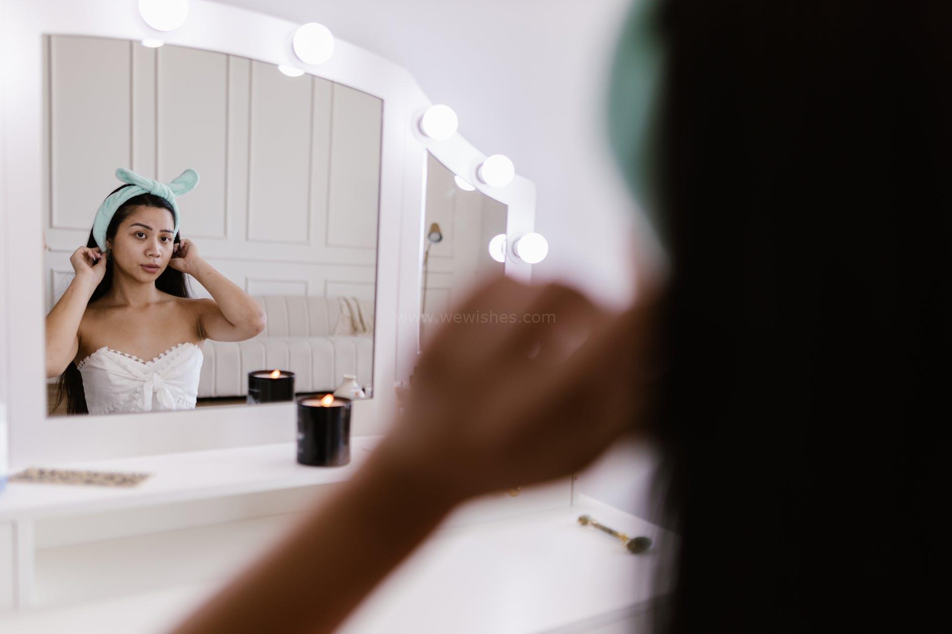 woman sitting in front of a vanity mirror