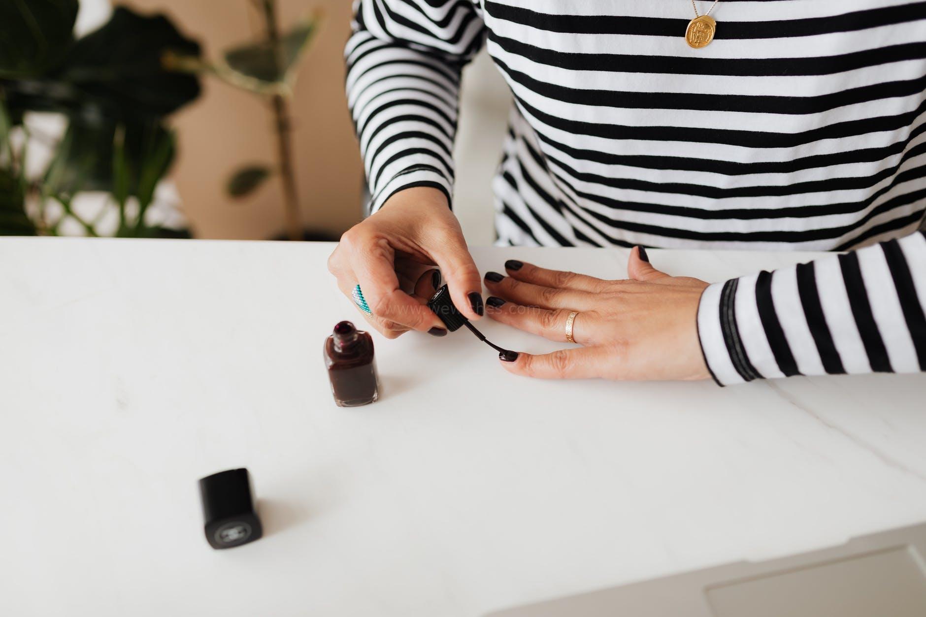 crop woman doing manicure at home