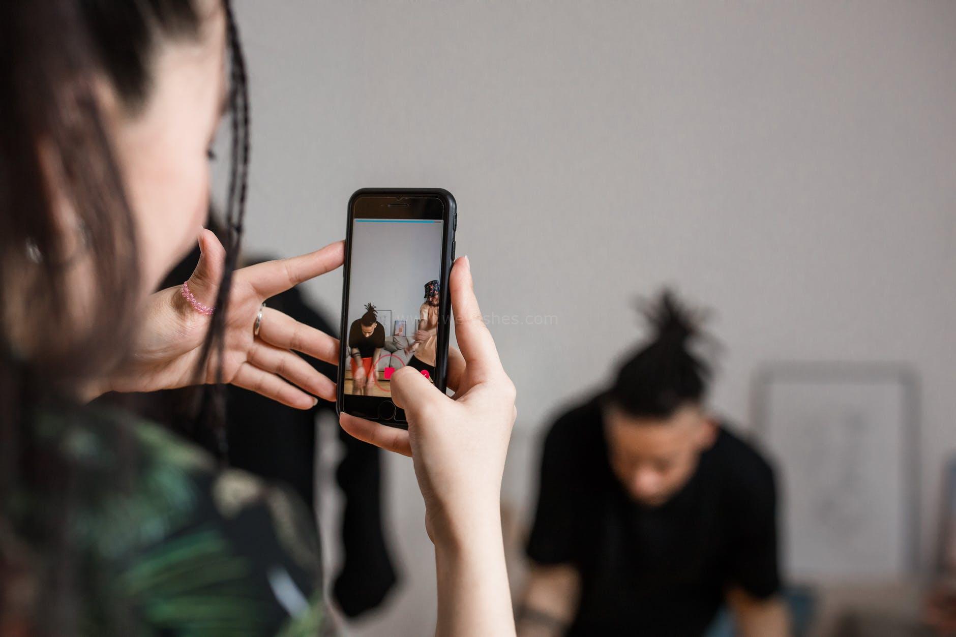 shallow focus of a person holding a smartphone while recording
